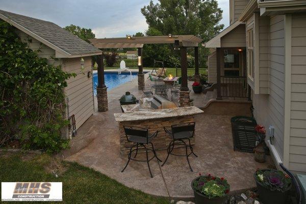 Trex Pergola with stone wrapped columns and custom grill island