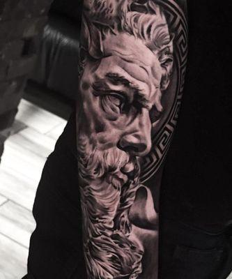 This is a black and grey Greek god tattoo.