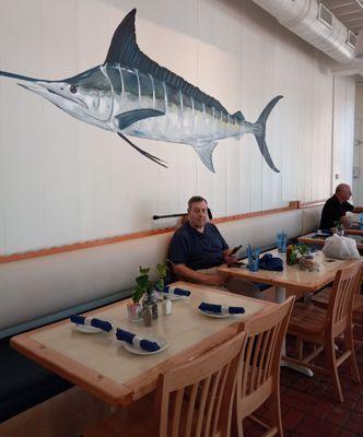 A long banquette in the back with more handsome decor - my spouse (and a beautiful Marlin).