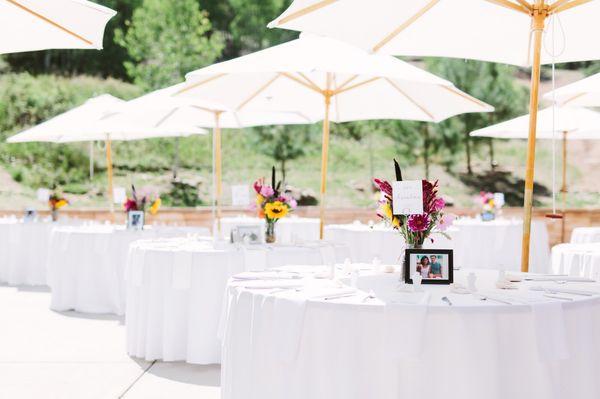 Table set up and umbrellas done by Walter Burke Catering. Flower arrangements, table numbers, and framed photos were set privately.