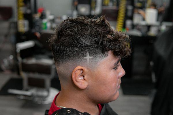 Mid skin fade with a criss design