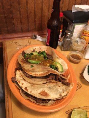 Three quesadillas with steak. Límon and cilantro on the side as requested.