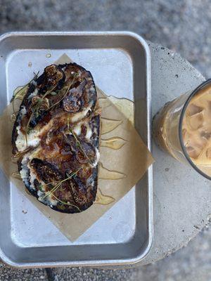 Fig toast with sliced figs, ricotta, fig jam, honey, thyme, and rustic bread.