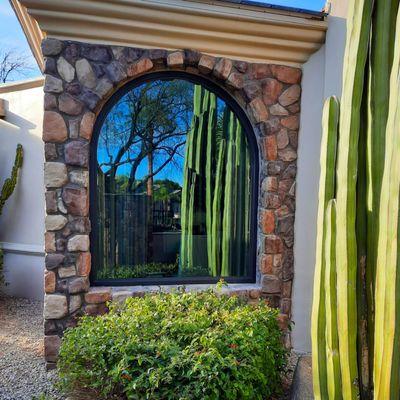 Half circle with legs window. Installed in a stone exterior home.