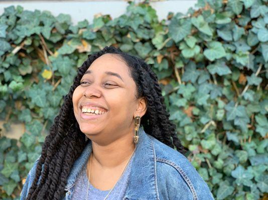 Jacinta smiling in front of a wall of vines in downtown Las Vegas.