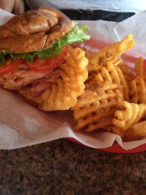 Turkey & ham on a pretzel roll with fries.