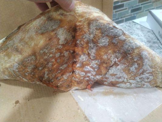 Excess flour on bottom of a pizza after scraping the rest of!