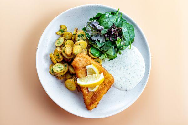 Backfish: Bier battered pollock served with remoulade sauce, pan-seared potatoes, marinated greens, and lemon.