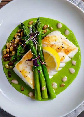 Pan-seared seabass perfection! Delicate asparagus velouté, peppery microgreens, and a squeeze of lemon.