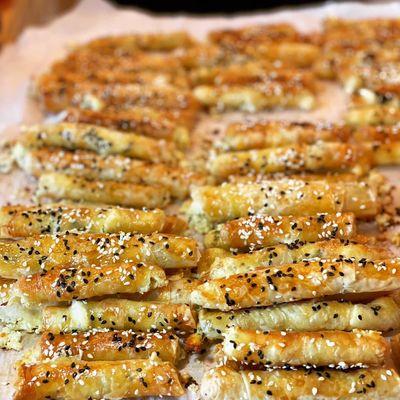 Turkish Cigar Rolls: Feta & Herb rolled in Filo topped with sesame Seeds.