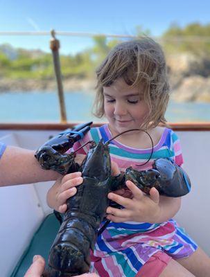 Mica holding a giant lobster on the Finest Kind lobster boat!