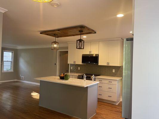 Wood industrial ceiling accent piece with light fixtures over kitchen island