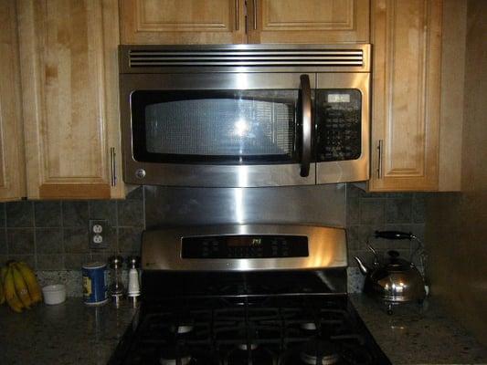 Kitchen update, cabinets,stove, microwave, counters, and tile backsplash