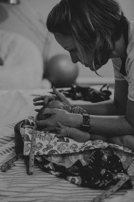 Brittany doing a newborn exam on a client's new baby