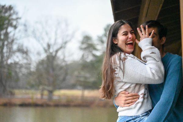 Playful moment between couple in a gazebo.