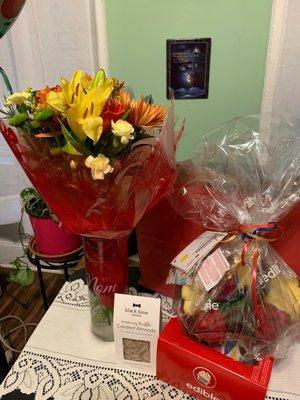 Arrangement with flowers , cookies, and a fresh fruit arrangement with chocolate dipped strawberries I ordered for my mother .