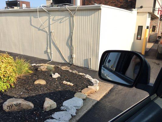 Rock garden with biblical sayings on them in drive through line.