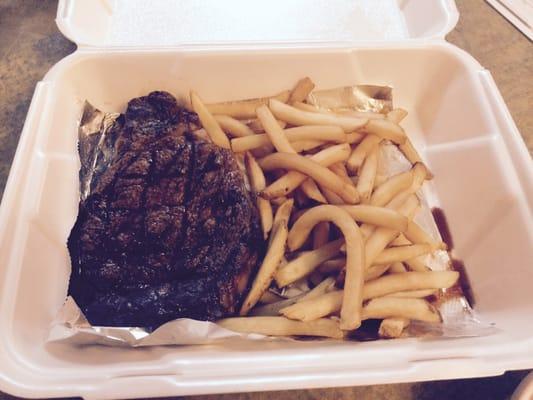 14 oz ribeye with a side of fries in a go box.