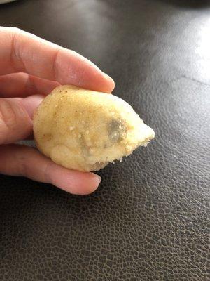 The end of a breadstick with two moldy spots.