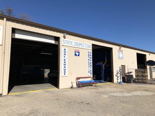 One Stop Muffler Shop (sign showing they do safety and emissions inspections for the state of Texas)