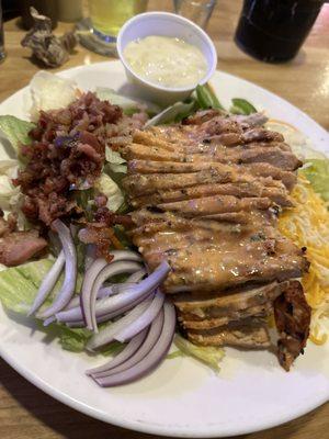 Grilled chicken salad with a wing sauce on it makes a great meal