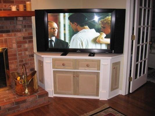 This plasma TV used it's pedestal stand and sat on top of a custom built cabinet.