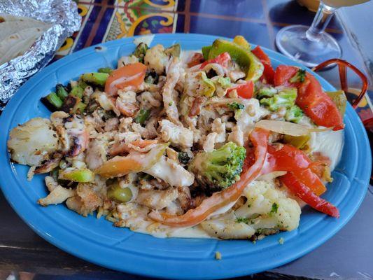 Pollo con arroz also known as grilled chicken over a bed of rice and vegetables with queso cheese on top!