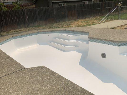 resurfaced fiberglass pool with new tile (prior to water)