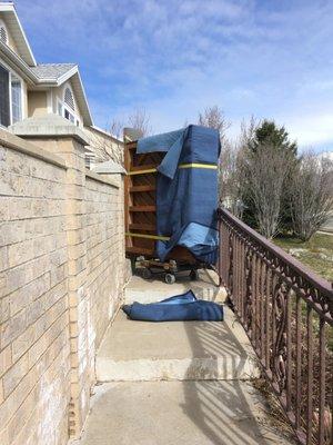 Tight squeeze with a cabinet grand out of a house.