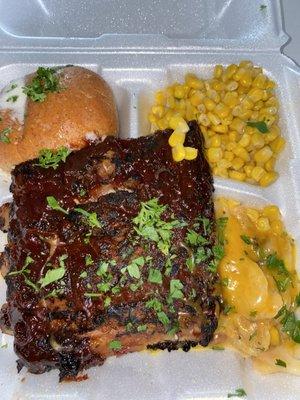 Fire braised rib dinner with corn, buttered bun and some scalloped potatoes.