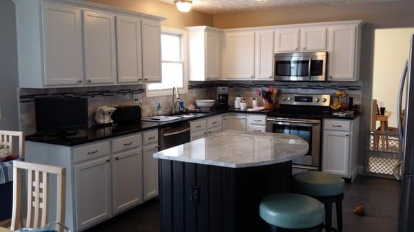 White kitchen with black island.