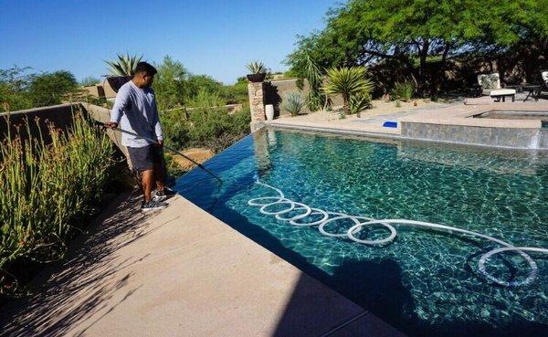 Vacuuming a pool.