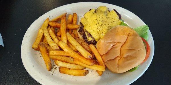 Double cheeseburger cooked perfectly and dressed with tomato lettuce pickles.