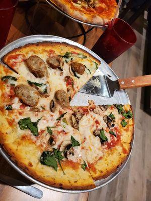 Cauliflower pizza with fennel sausage, basil, spinach and mushrooms.