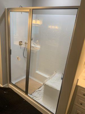 In-line framed shower enclosure with brush nickel hardware