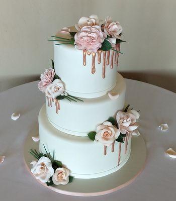 Wedding cake with rose gold drizzle, and all edible handmade roses, leaves and pine needle accents.