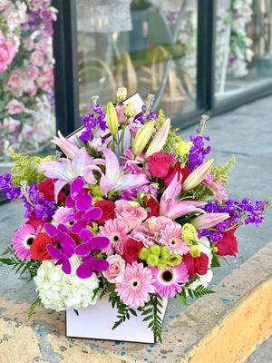 Beautiful mix of pink, purple flowers & fillers in a white box