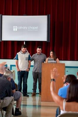 The children's ministry director and the music and media director being prayed for.