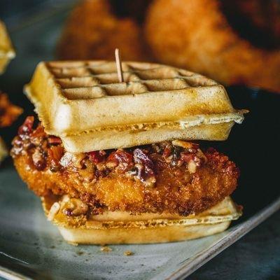 Chicken and Waffle sandwich with a side of onion rings