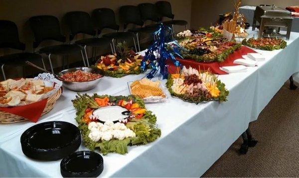 A full catering setup with various entrees, salads, and sides by Cranberry Hills Eatery & Catering is designed for events and...