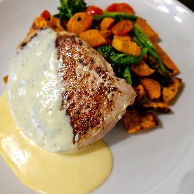 Seared 8oz Pork Ribeye with brown mustard cream sauce, over roasted sweet potatoes, broccolini, and grape tomatoes