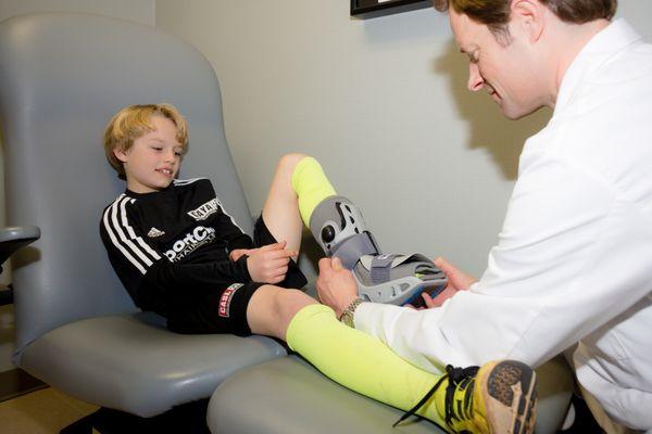 Dr. Kirk Woelffer assists with a sports injury at Raleigh Foot & Ankle Center.