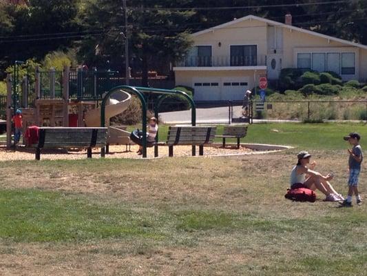 Outdoor playground with woodchips and older structures in a nice setting.