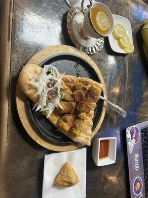 Chicken kabobs, samosa, and green tea with lemon.