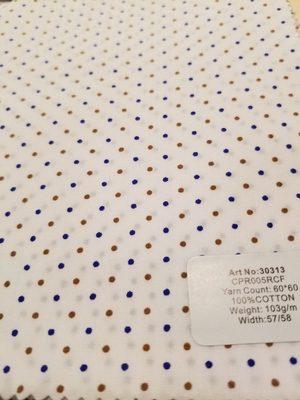 Blue and tan dots on white shirting fabric