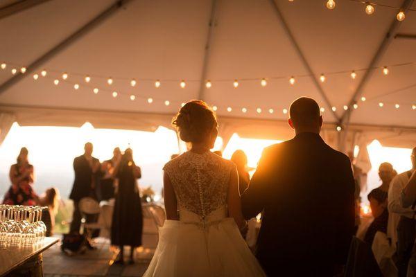 Wedding Tent Rental With Bride And Groom Under Tent With Lighting And bar