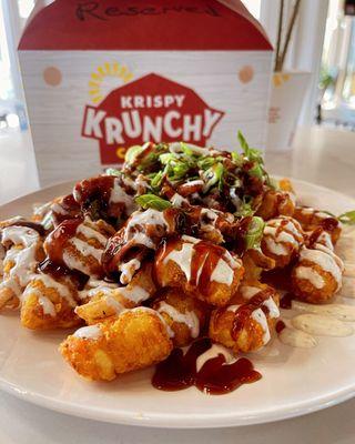 Loaded Tater Tots, with honey bbq pulled pork, scallions, Bourbon cheese sauce, and garlic sauce