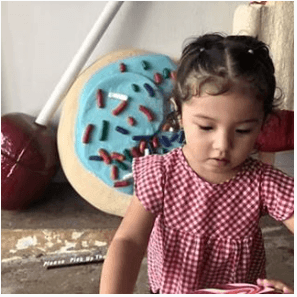 Really cute girl In front of the giant sugar cookie made by Fulton Boggs at POP LA.