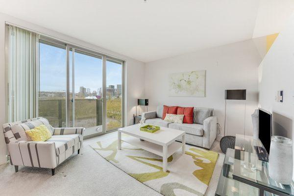 Staged living room area with floor-to-ceiling windows.