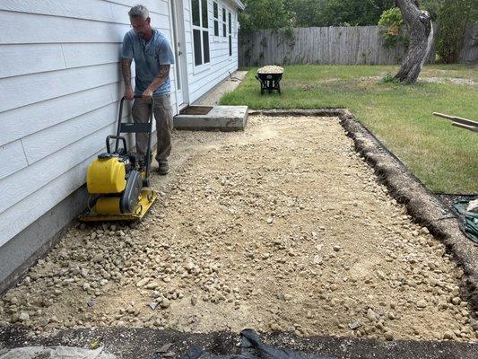 Al, one of our managing partners tamping base for a concrete back patio.